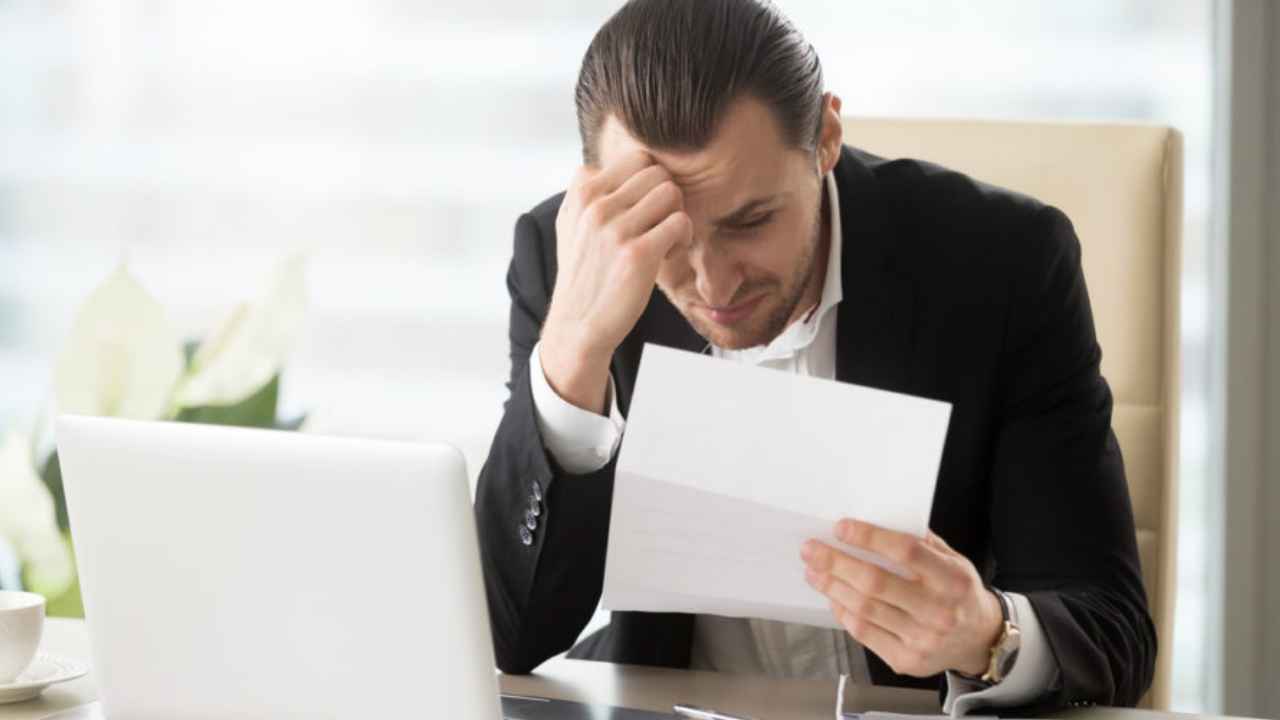 Trabajador preocupado tras recibir una carta de despido y tener que devolver una indemnización