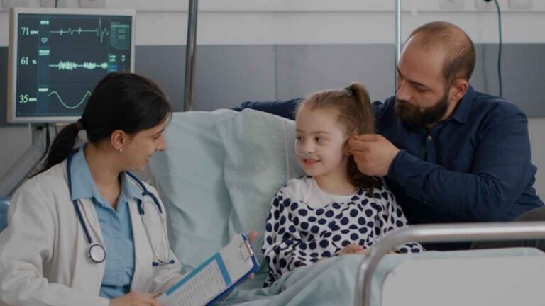 Padre junto a su hija hospitalizada durante una consulta médica por una enfermedad grave