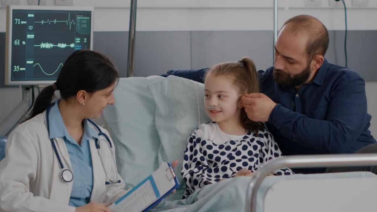 Padre junto a su hija hospitalizada durante una consulta médica por una enfermedad grave