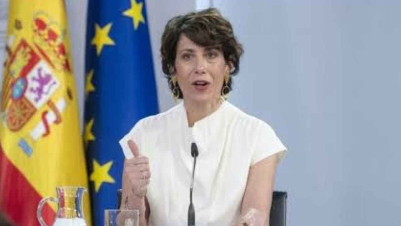Representante del Gobierno durante una comparecencia con las banderas de España y la Unión Europea
