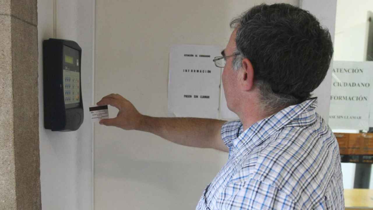 Trabajador fichando con una tarjeta en un sistema de control horario