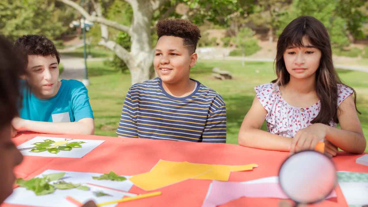 Niños realizando una actividad de manualidades al aire libre.