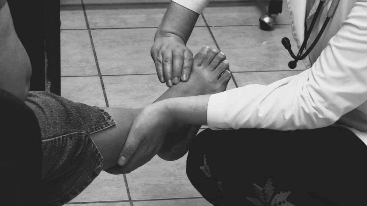 Una profesional sanitaria examina el pie de una persona durante una consulta.