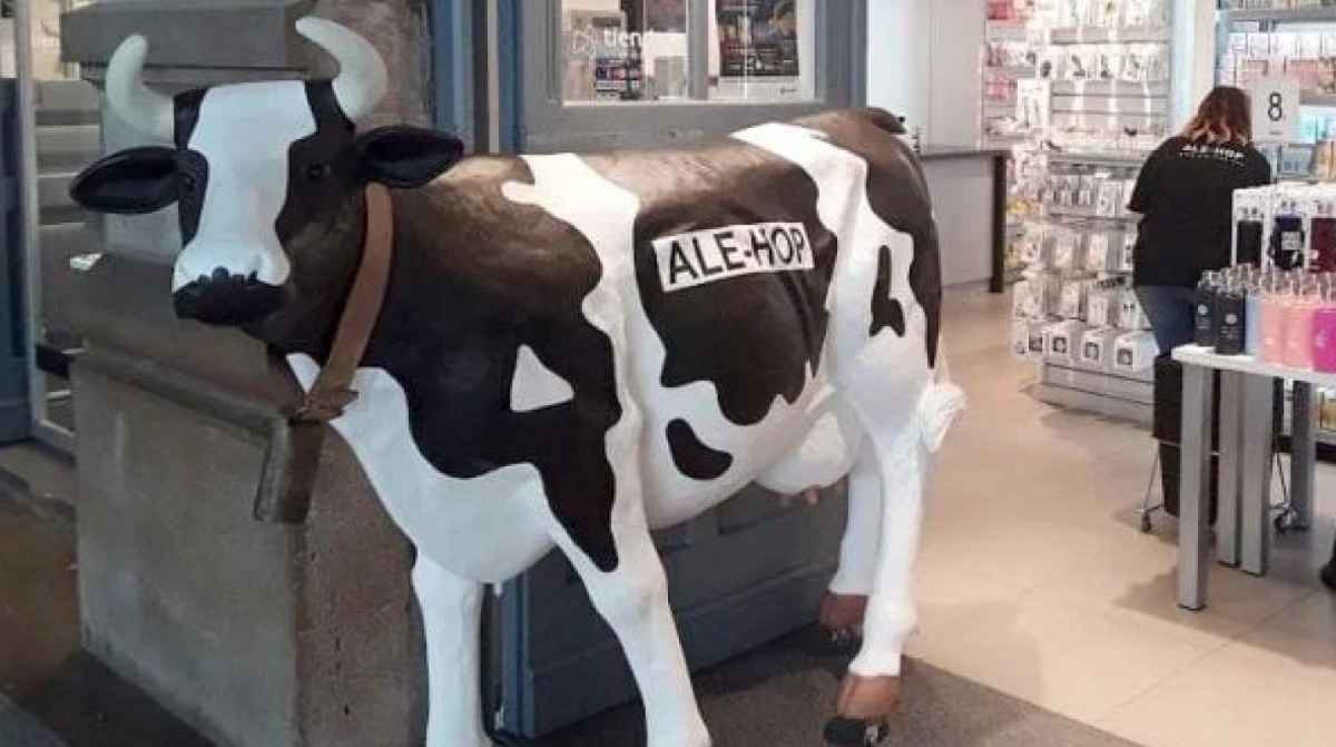 Entrada de una tienda ALE-HOP con la figura de una vaca en la puerta