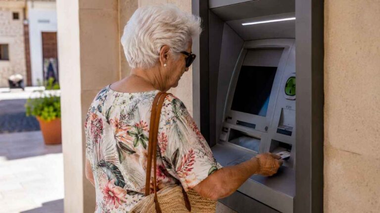Mujer mayor retirando dinero de un cajero automático