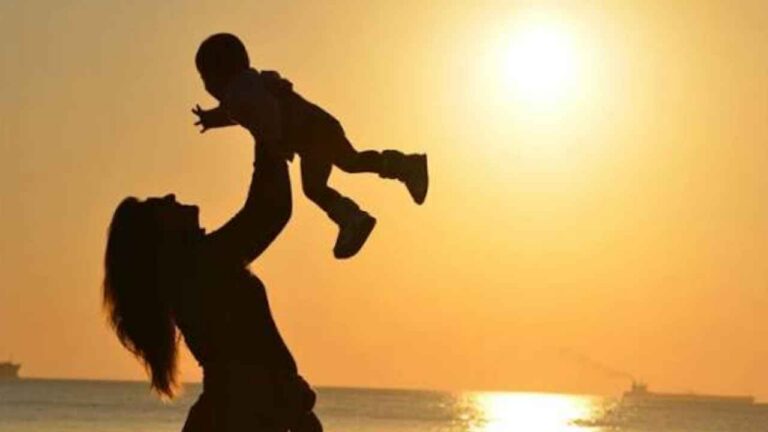 Madre jugando con su hijo al atardecer como imagen de conciliación familiar y laboral
