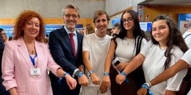 Grupo de asistentes a un evento de empleo del SEF mostrando sus pulseras azules.