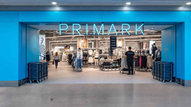 Personas esperando junto a la entrada de una tienda Primark en un centro comercial.