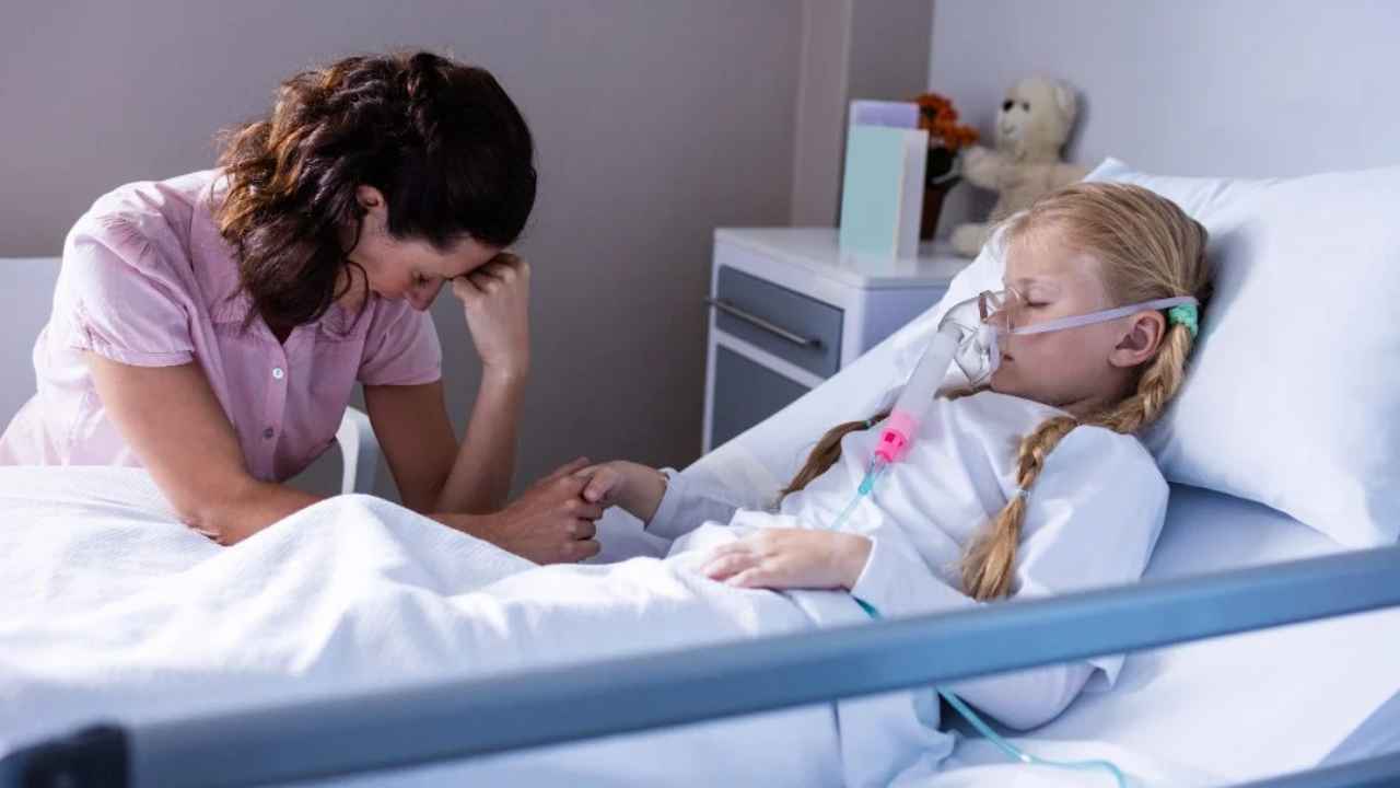 Madre acompaña a su hija hospitalizada mientras la cuida, una situación relacionada con el permiso CUME por enfermedad grave.