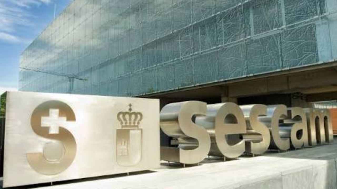 Rótulo del Sescam frente a la fachada acristalada de su sede en Castilla-La Mancha.