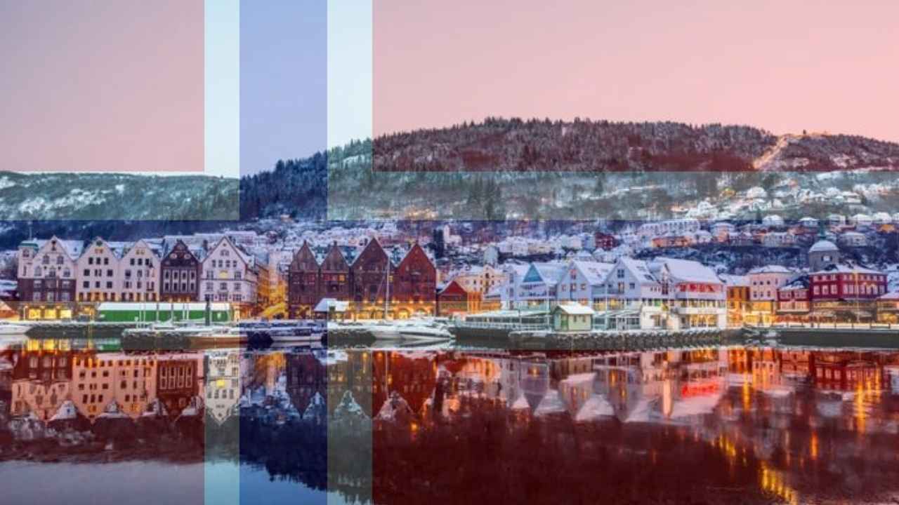 Paisaje urbano nevado junto al agua con la bandera de Noruega superpuesta.