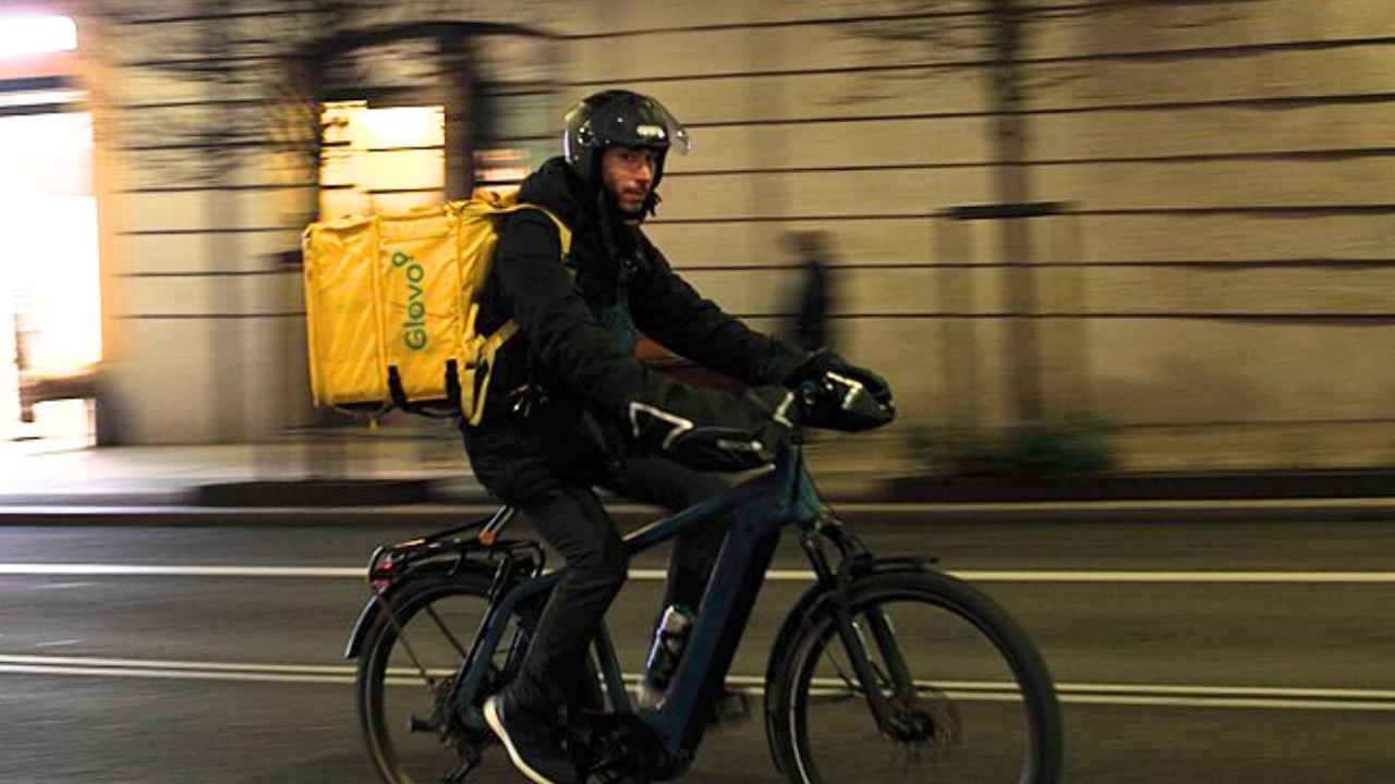 Repartidor de Glovo en bicicleta por la Gran Vía de Madrid.