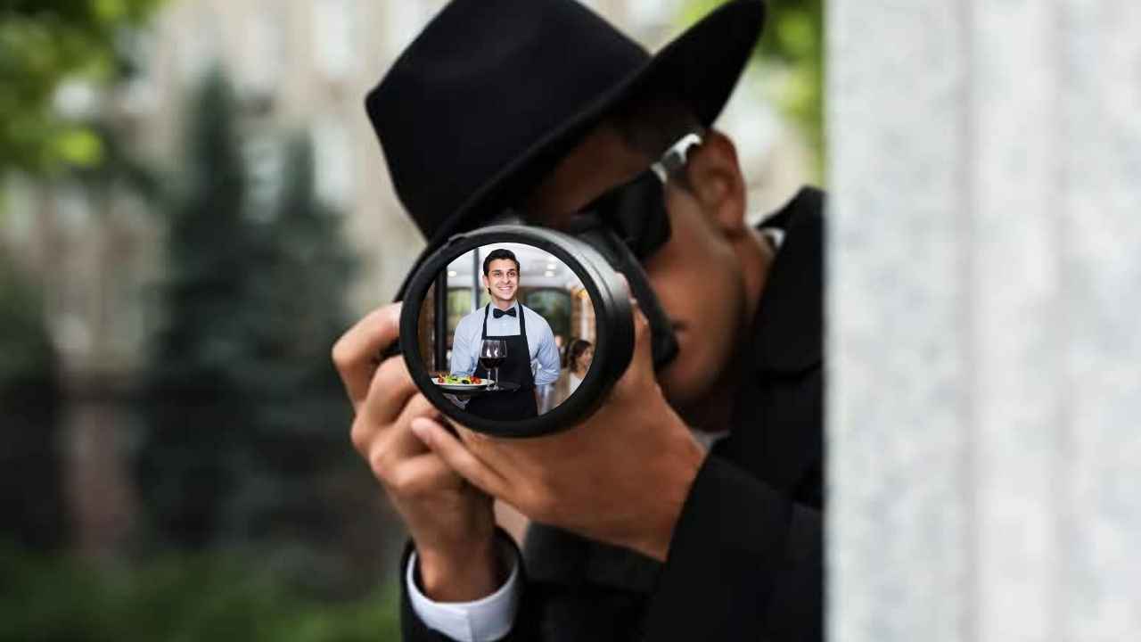 Detective privado con una cámara fotográfica realizando labores de vigilancia desde detrás de una columna