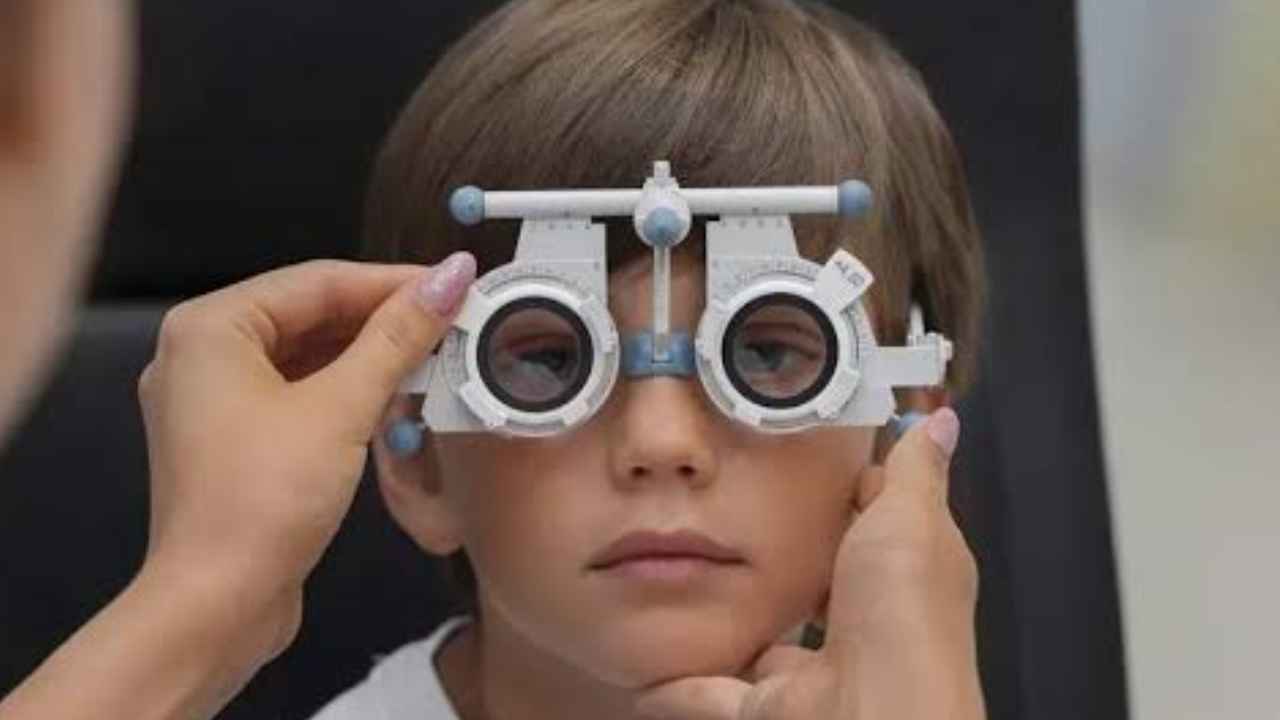 Niño durante una revisión de la vista con gafas de prueba para graduación, relacionada con la ayuda de 100 euros del Plan Veo