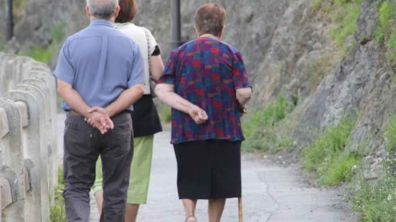 Dos personas mayores caminando por un sendero junto a otra persona, imagen ilustrativa de la autonomía personal