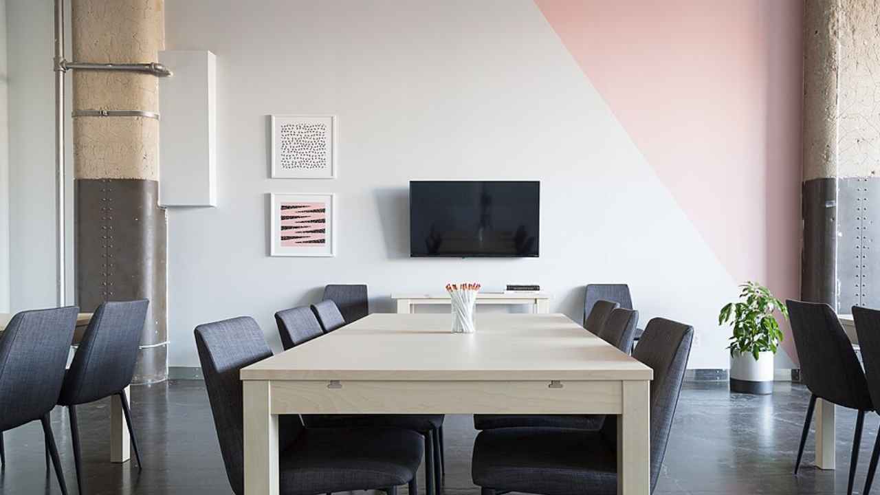 Sala de reuniones vacía con mesas y sillas.