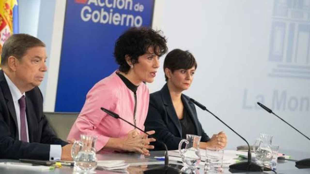 Rueda de prensa del Gobierno de España con tres representantes institucionales en la sala de La Moncloa.