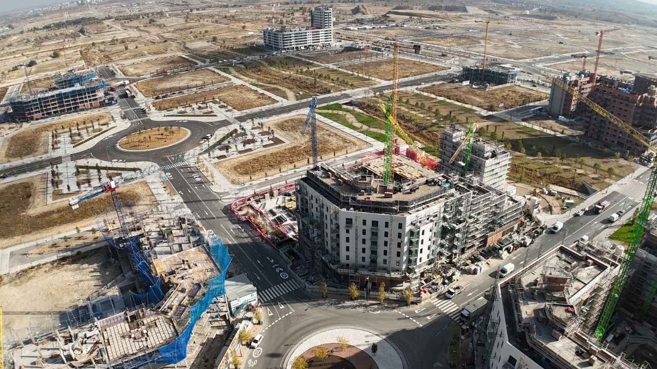Vista aérea de edificios de viviendas en construcción, con grúas y nuevas calles urbanizadas en Los Berrocales, Madrid.
